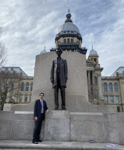 Image of CUB's Director of Governmental Affairs Bryan McDaniel standing in front of the Illinois State Capitol building in Springfield. 